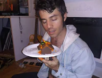 a man holding a plate with a cake on it